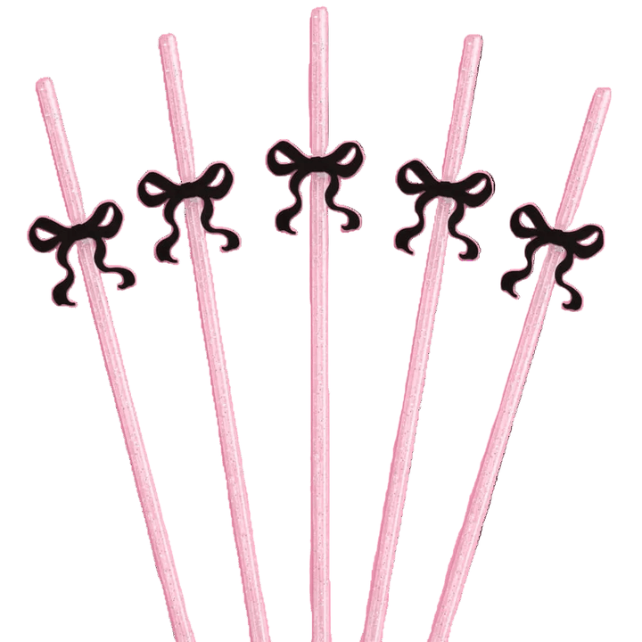Pink glitter reusable party straws each topped with a black bow charm for a coquette themed celebration