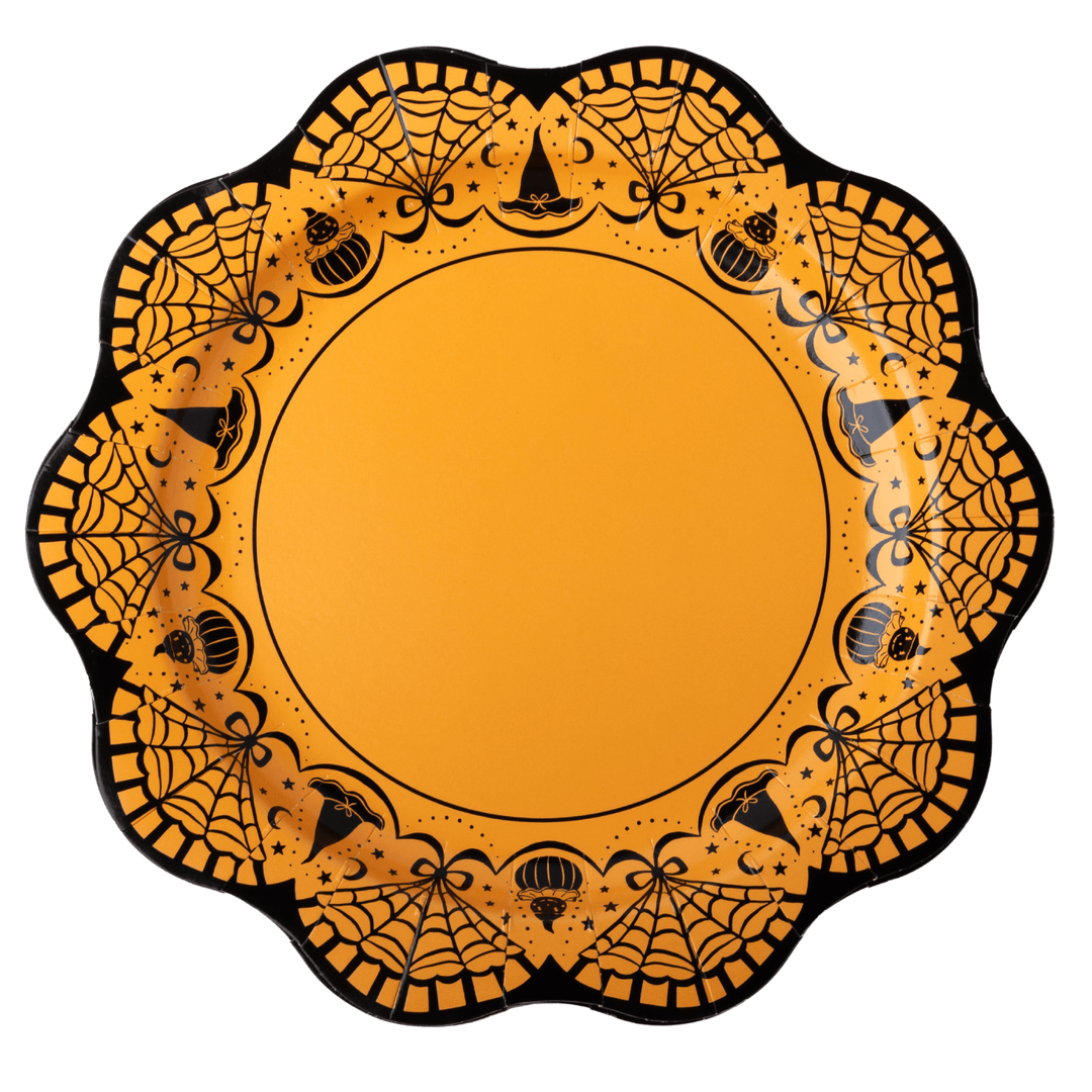 An orange and black scalloped Halloween party plate with spiderwebs, bats, and pumpkins around the rim.