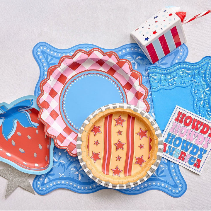 Patriotic cake slice cup with strawberry, pie, and Howdy plates on a blue scalloped tray