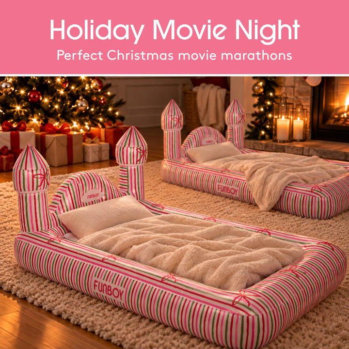 Two holiday castle kids air mattresses set up by a Christmas tree for a movie night