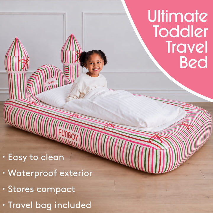 Toddler sitting on a holiday stripe castle air mattress with travel bed features listed