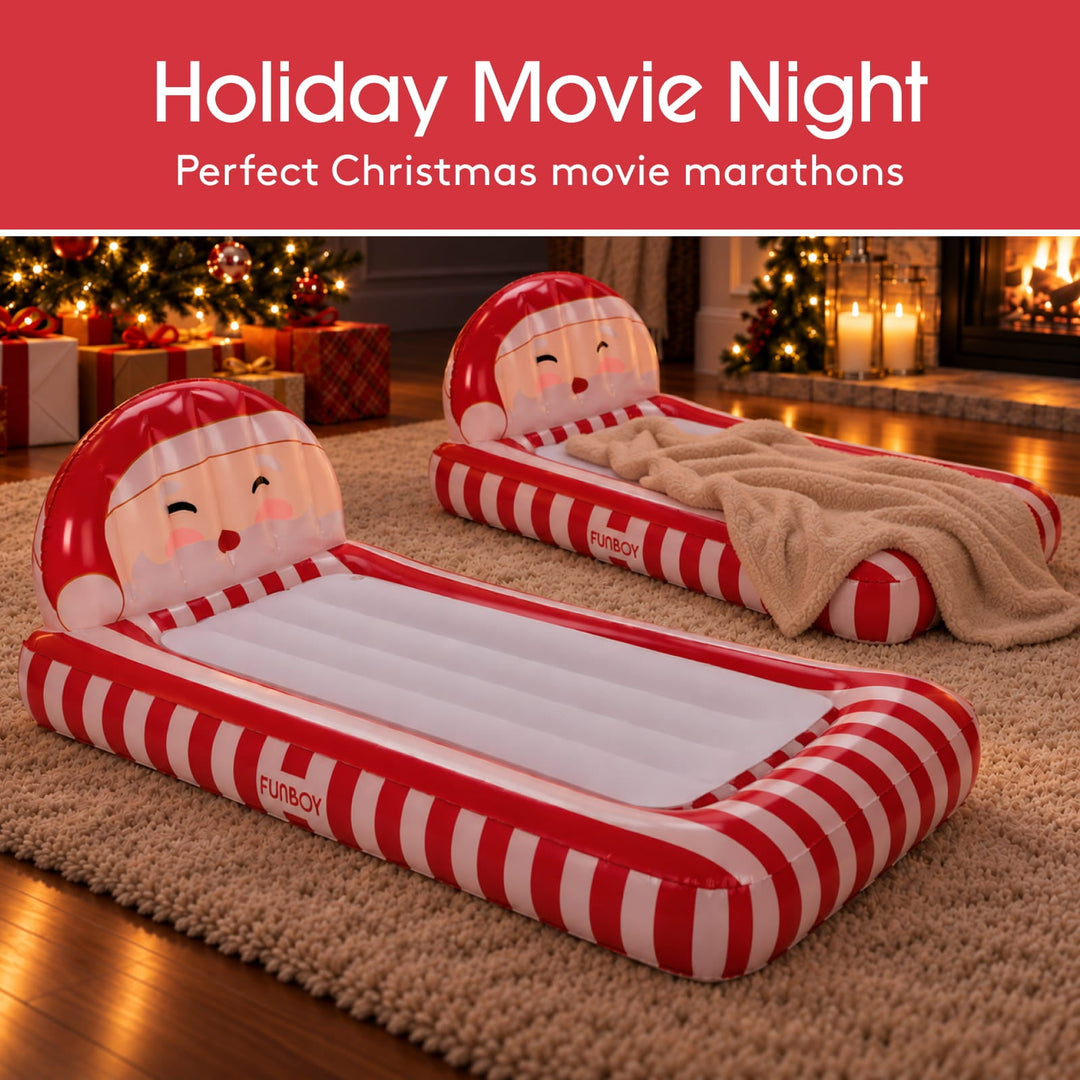 Two Santa kids air mattresses set up by a Christmas tree for a movie night