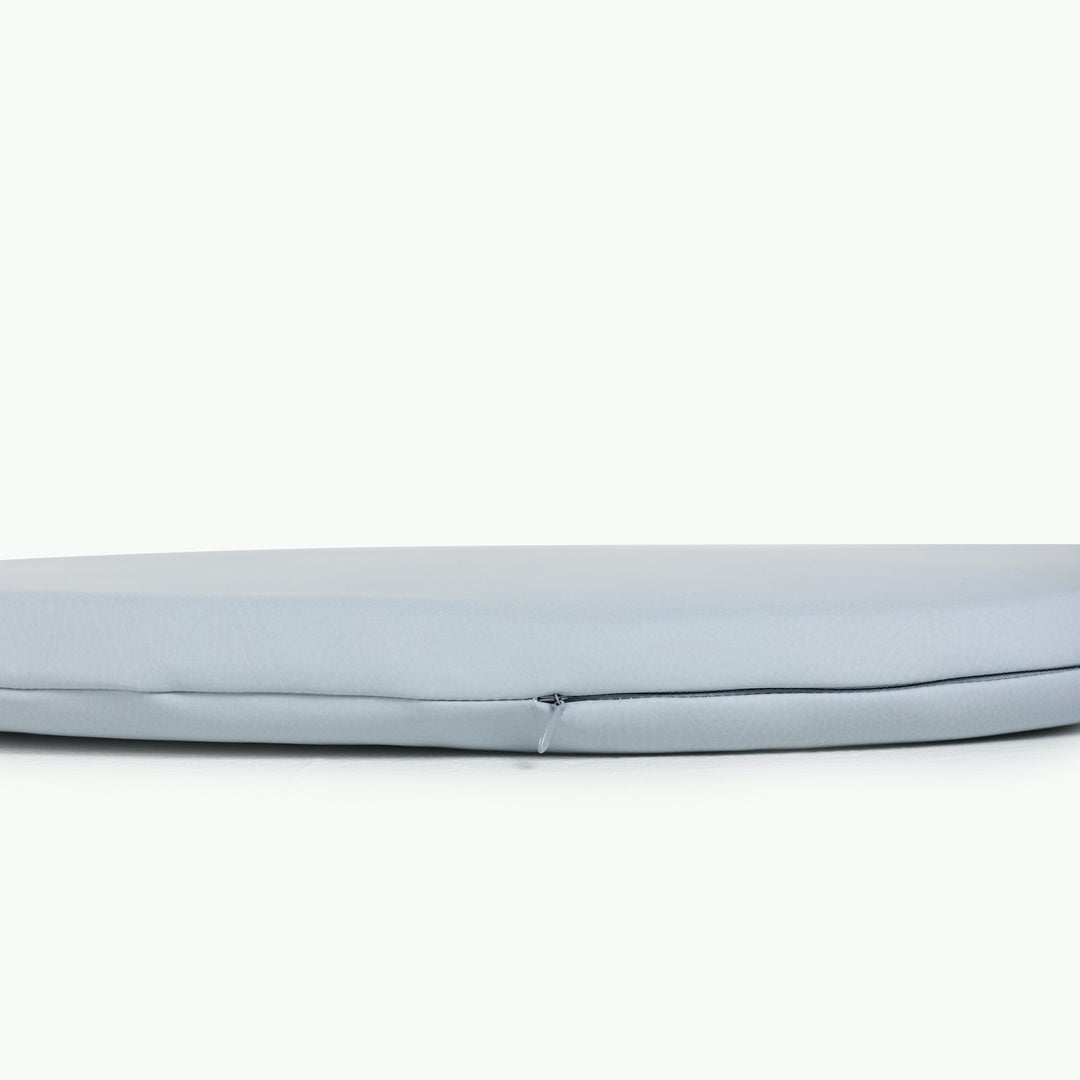 Light blue round padded play mat side view showing the cushioned edge and zipper.