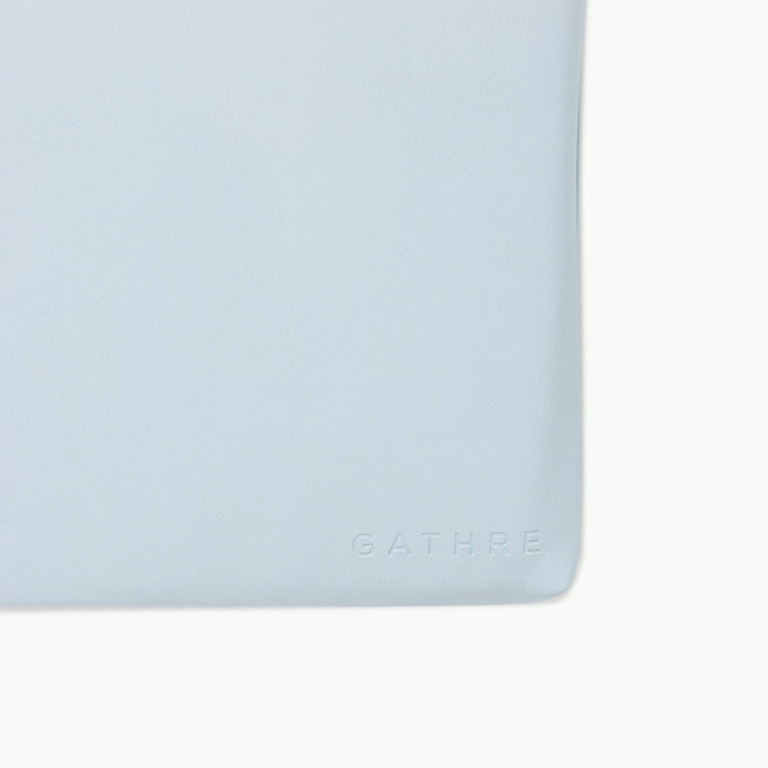 Light blue padded play mat, close-up of the wipeable vegan leather corner.