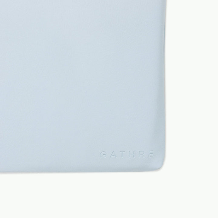 Light blue padded play mat, close-up of the wipeable vegan leather corner.