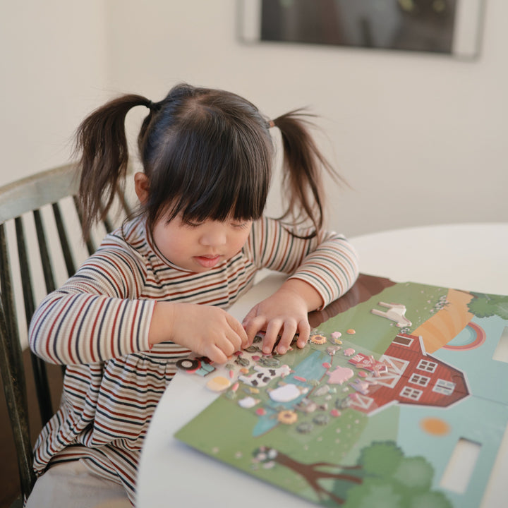 Two children sharing Mushie reusable sticker books