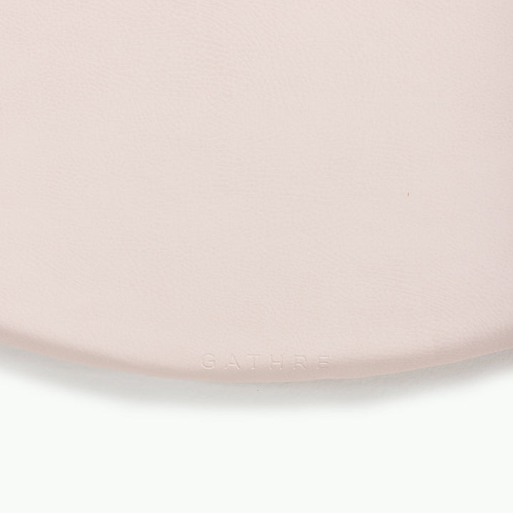 Cream blush round padded play mat, close-up of the soft wipeable surface.