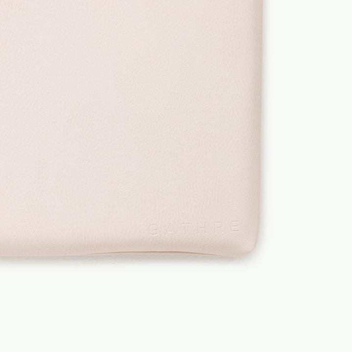 Cream blush padded play mat, close-up of the wipeable vegan leather corner.