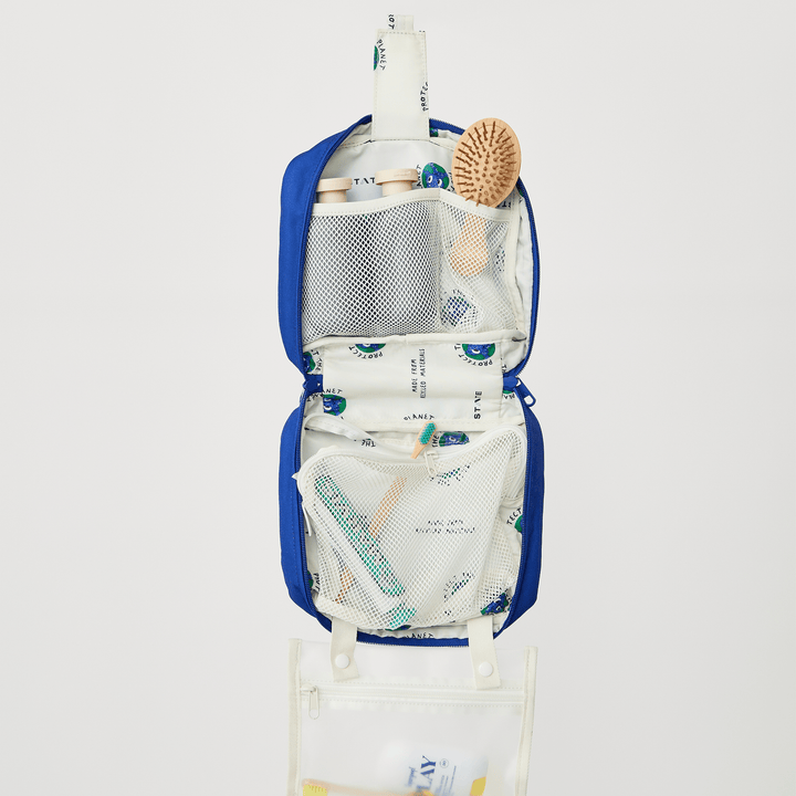 Packed Bensen upper compartment with a wooden hairbrush and toiletries in mesh pockets