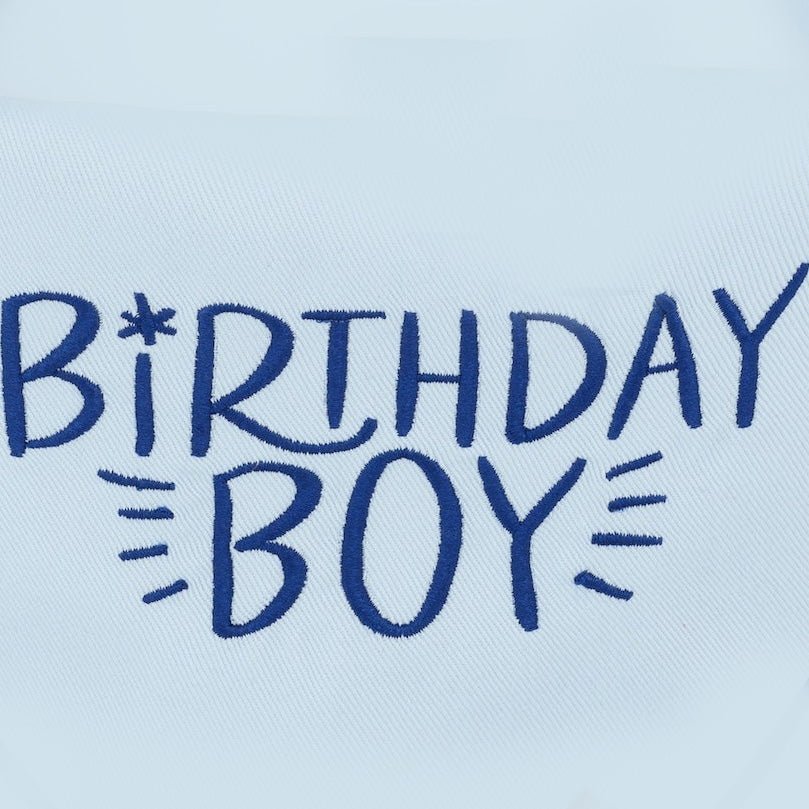 Close-up of navy Birthday Boy embroidery on soft light blue bandana fabric