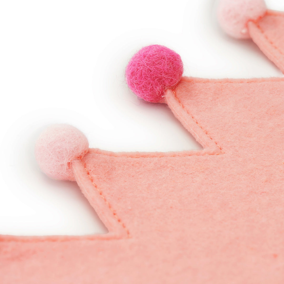 Close-up of the blush felt crown points with hot pink and pale pink wool pom-poms