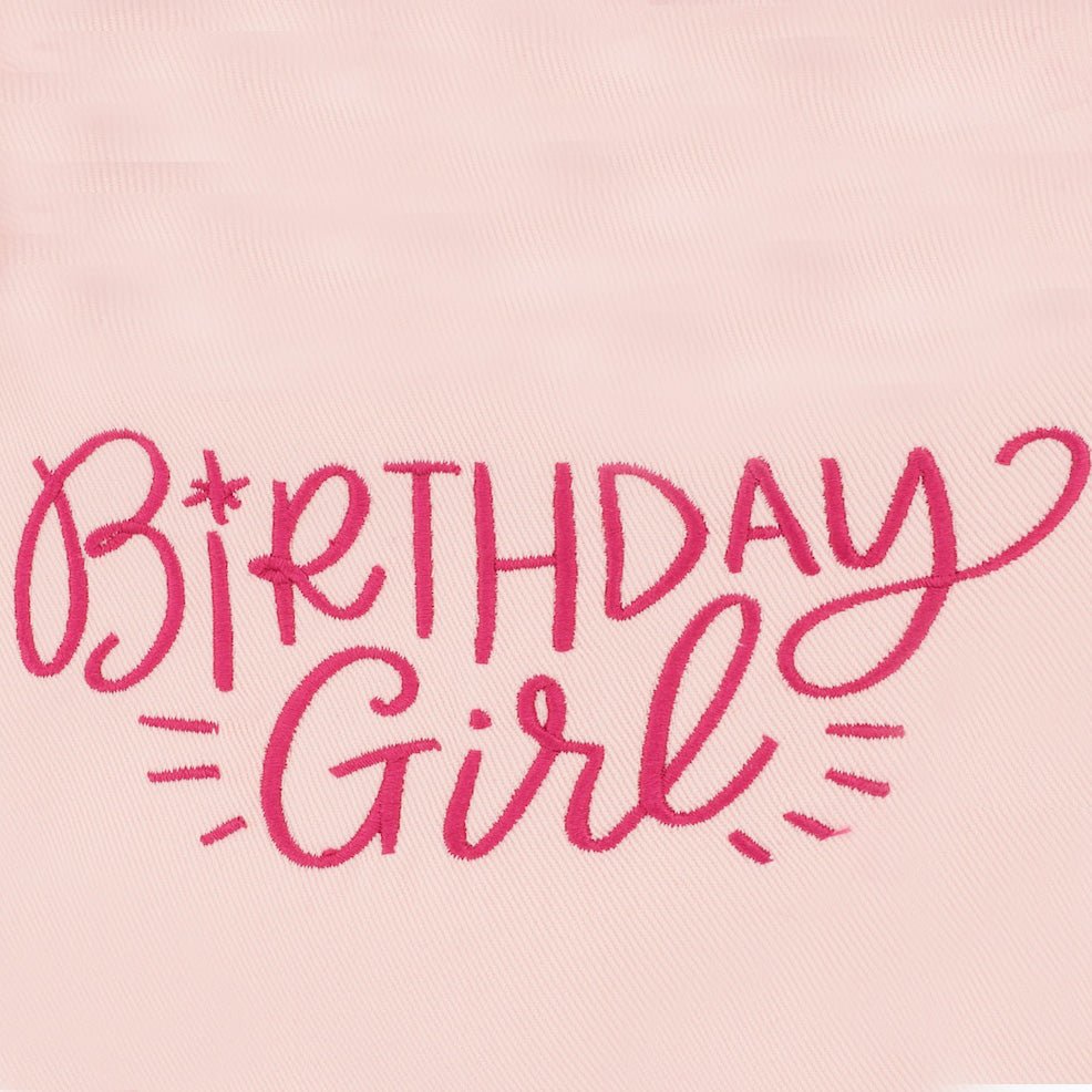 Close-up of hot pink Birthday Girl script embroidery on pale pink bandana fabric