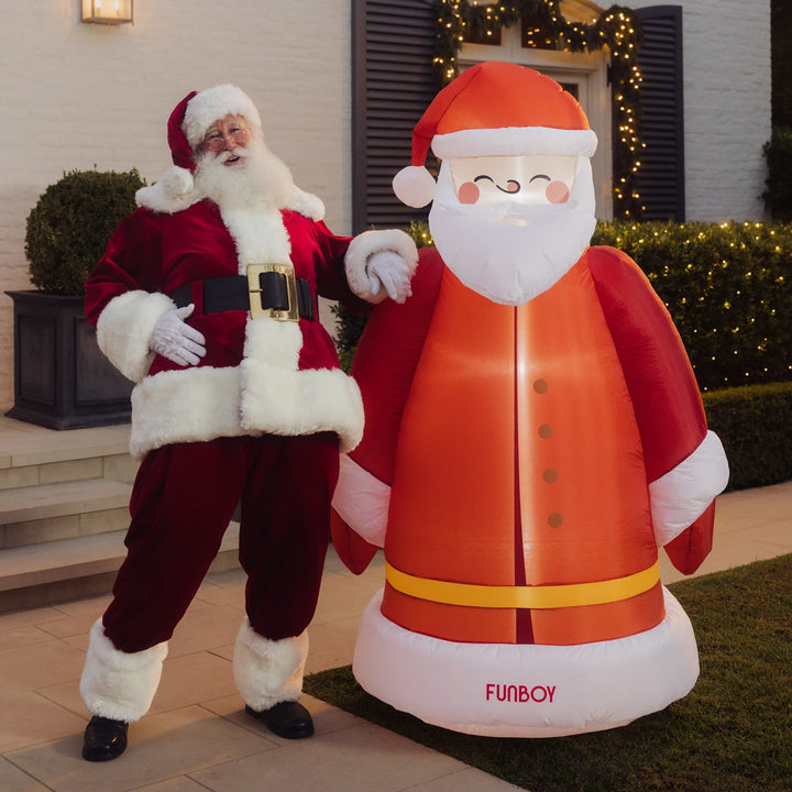 Person dressed as Santa standing beside the 6 ft inflatable vintage Santa