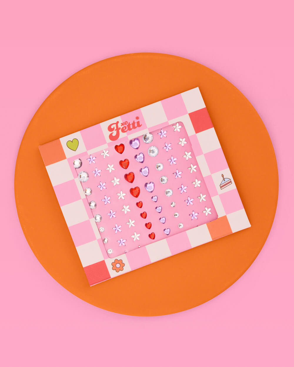 Heart and daisy eye gem card on an orange circle against a pink background