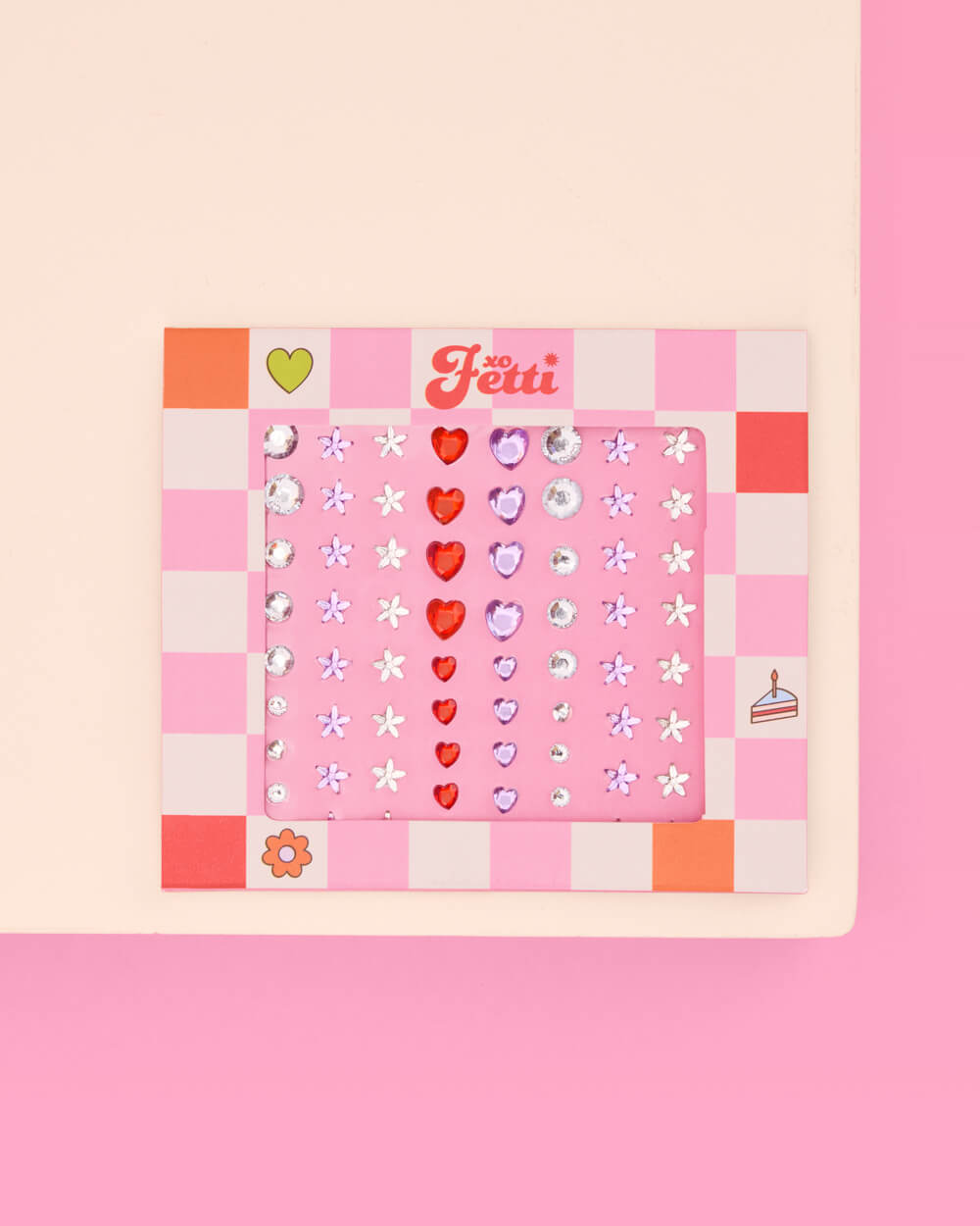 Heart and daisy rhinestone eye gem card shown flat on a cream and pink surface