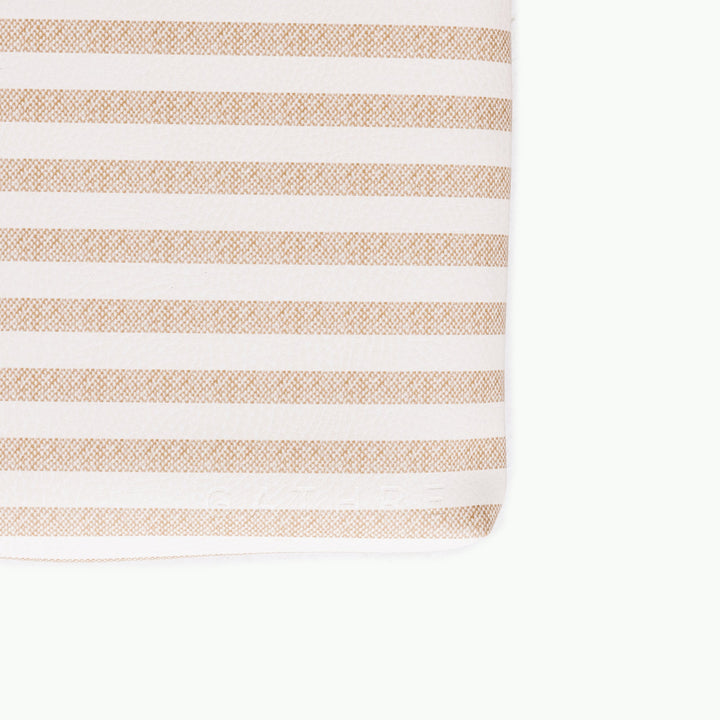 Close-up of the tan and white cafe stripe padded play mat fabric with an embossed logo