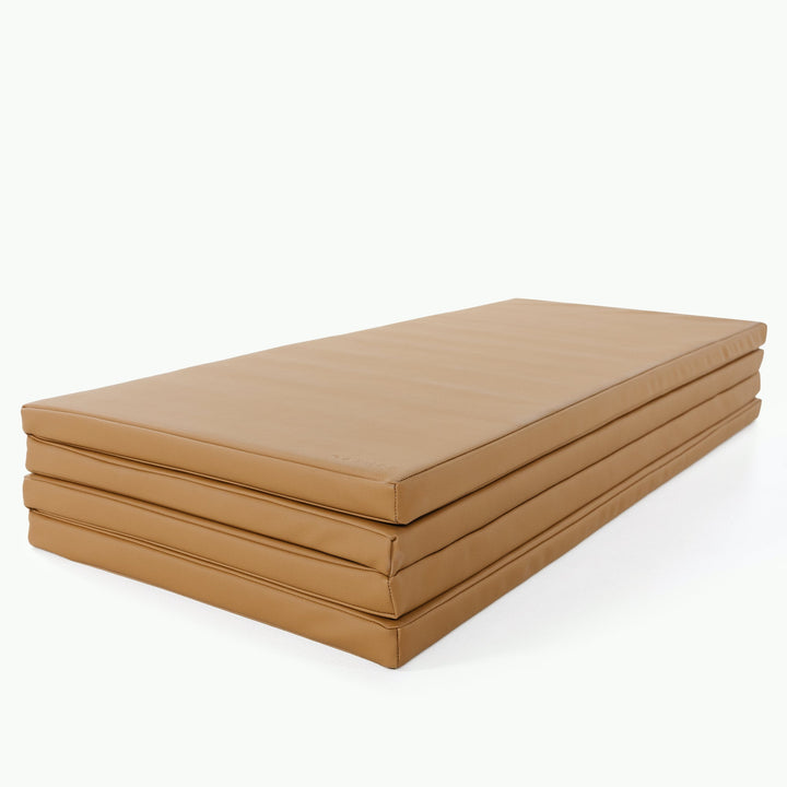 Camel vegan leather tumbling mat folded into four stacked sections for storage