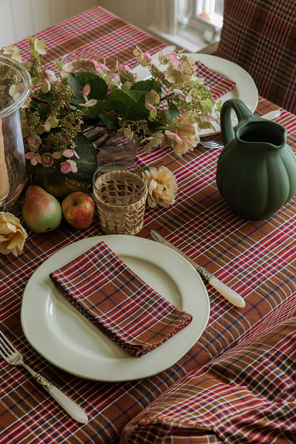 Charlotte plaid napkin folded on a cream plate at a holiday place setting with pears