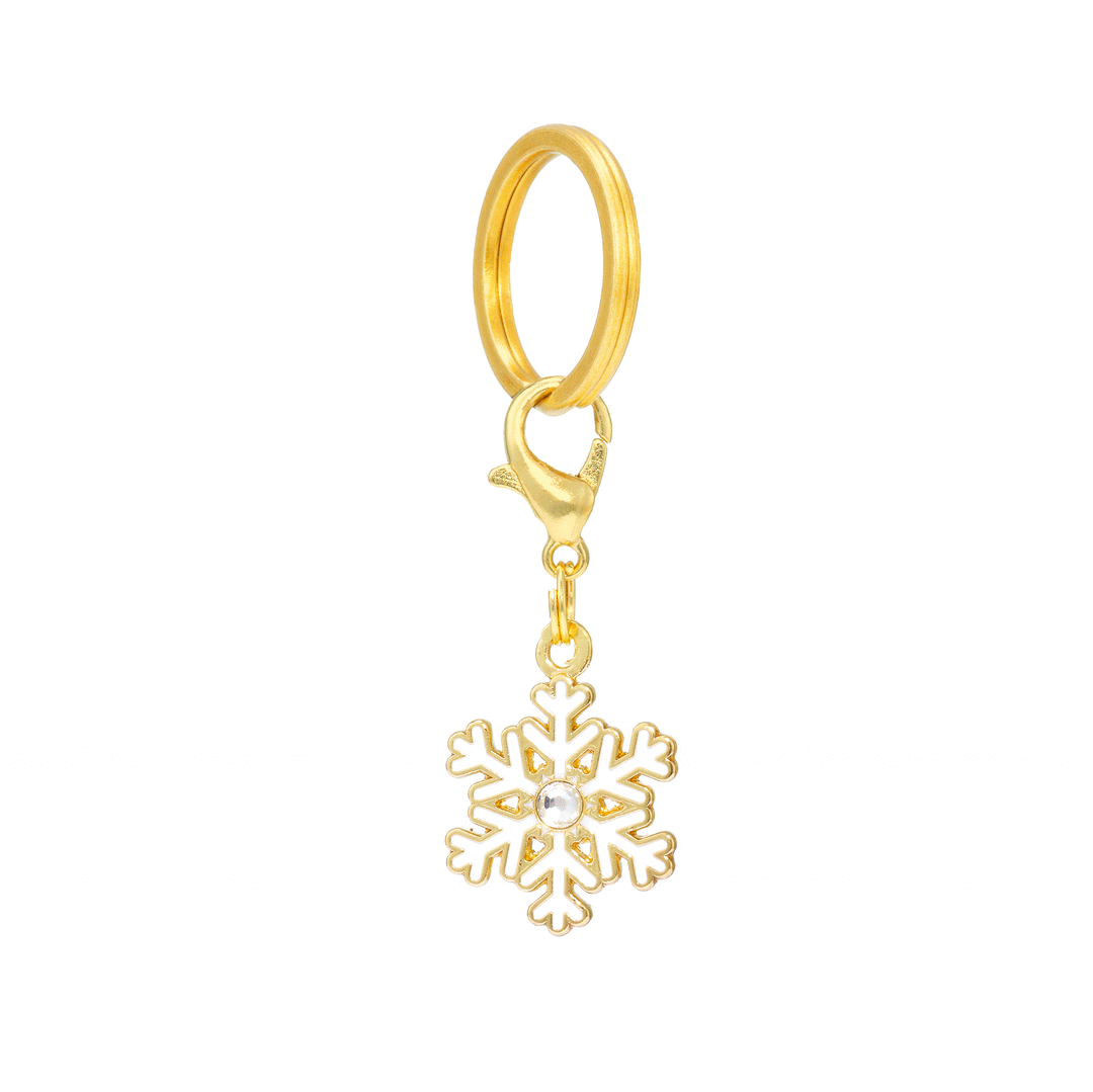 Snowflake dog charm seen edge-on, hanging from a gold split ring and clasp