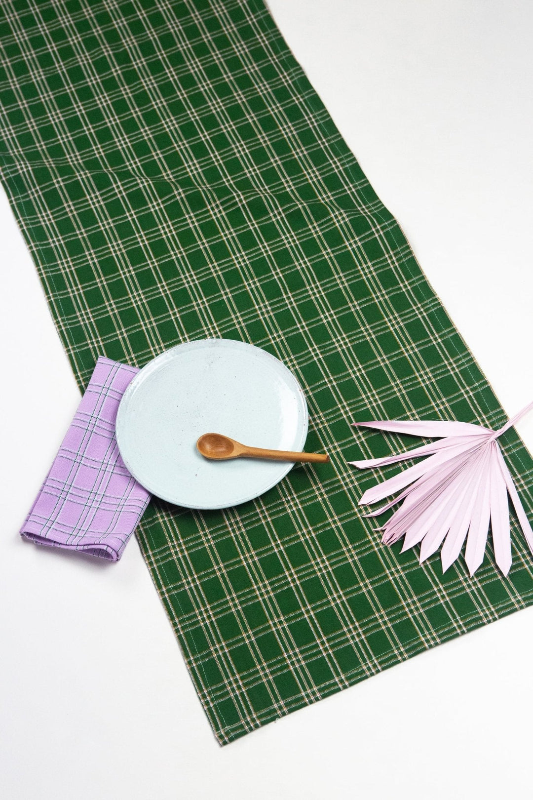 Forest green plaid table runner with ochre and lilac styled on a wood dining table