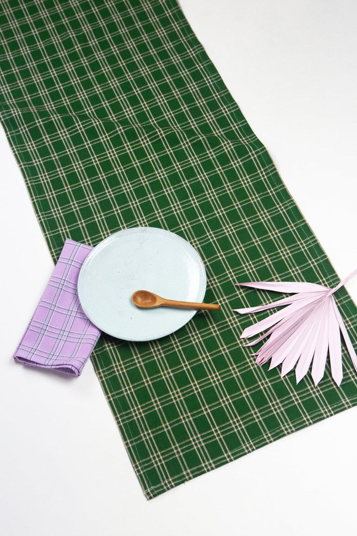 Forest green plaid table runner with ochre and lilac styled on a wood dining table