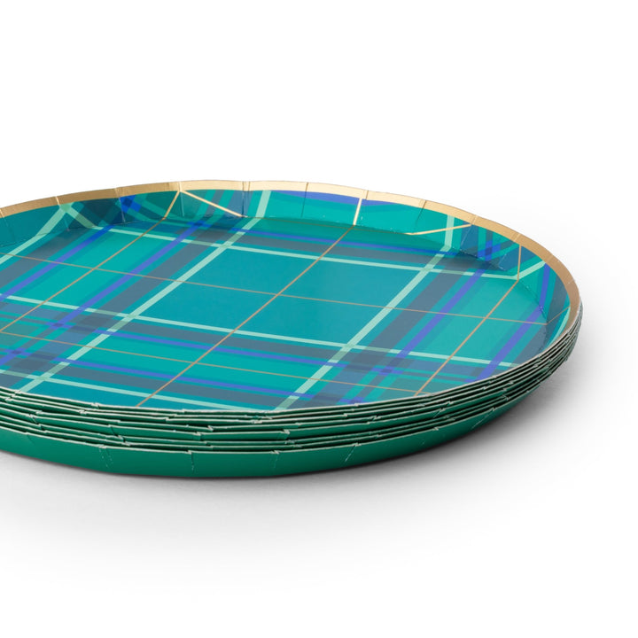 A stack of round paper plates with a teal and green plaid pattern and a gold rim, photographed on a clean white background.