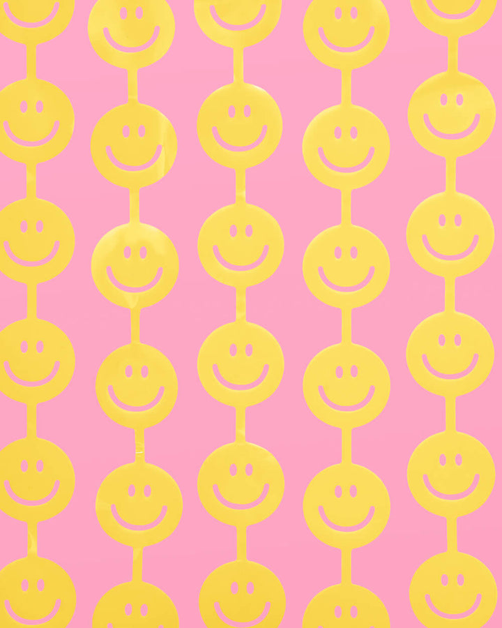Yellow smiley face curtain strands hung close together as a happy face party backdrop