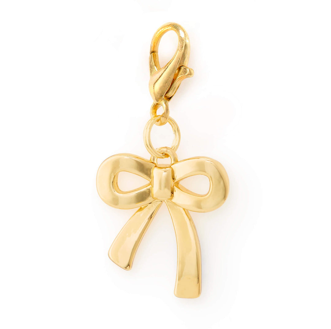 Polished gold three dimensional bow dog collar charm on a gold lobster clasp, on white