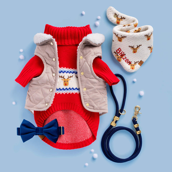 Flat lay on blue: reindeer sweater, quilted vest, navy bow tie, navy leash, and a reindeer bandana