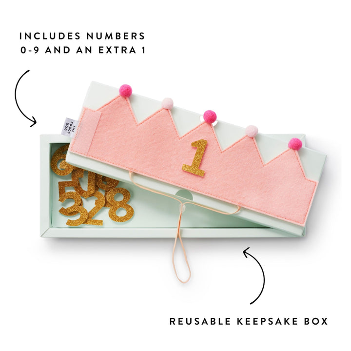 Blush crown showing 1 resting on its keepsake box of spare gold glitter numbers