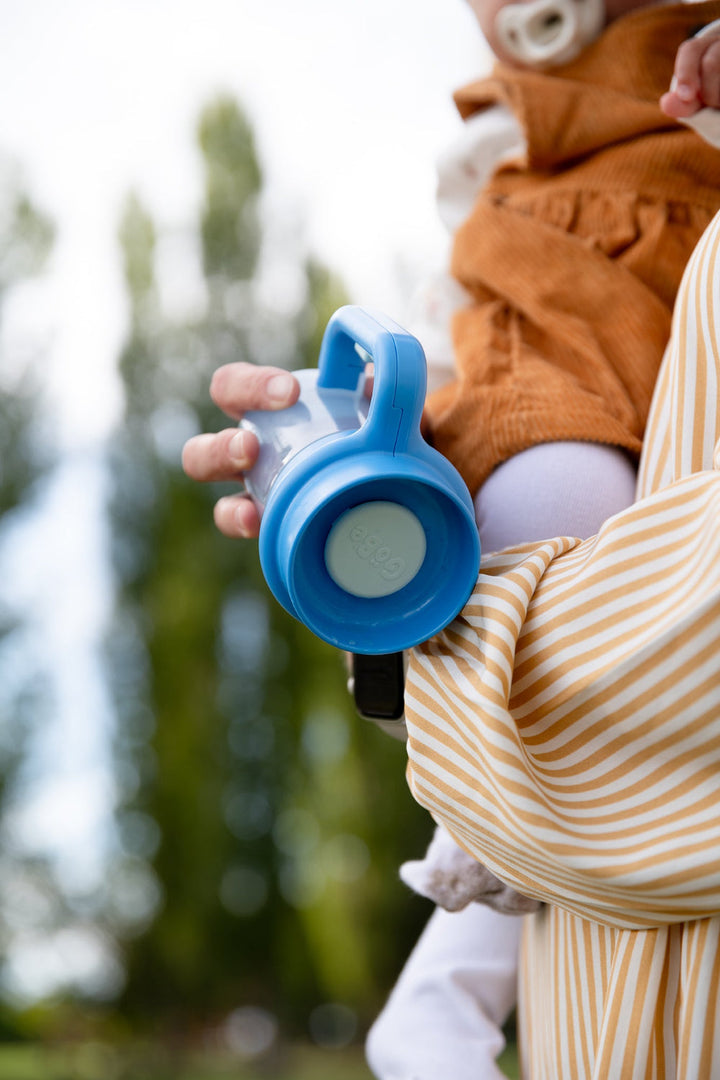 Close-up of a child's hand gripping the Wonder Cup handle outdoors