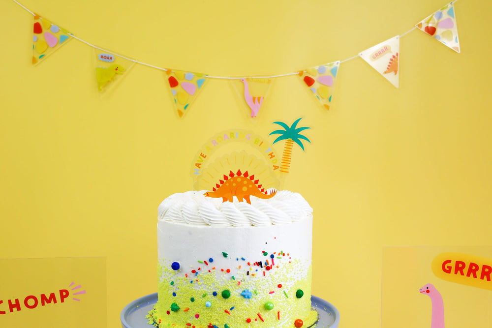 Acrylic dinosaur cake toppers in the Dino-mite design from Joyeux Company