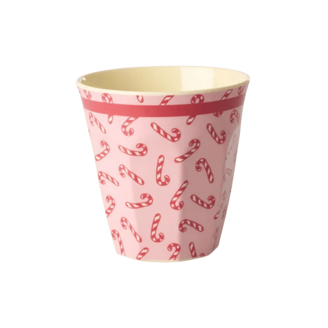 Pink melamine cup with red and white candy cane print and a red band at the rim, front view on white
