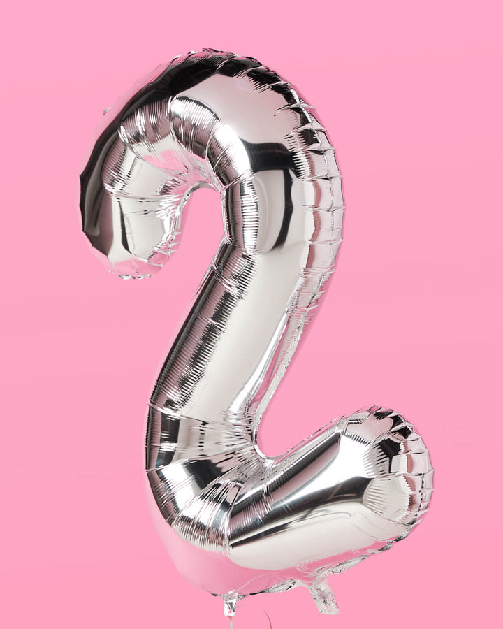 Silver 40 inch foil number 2 balloon against a pink background