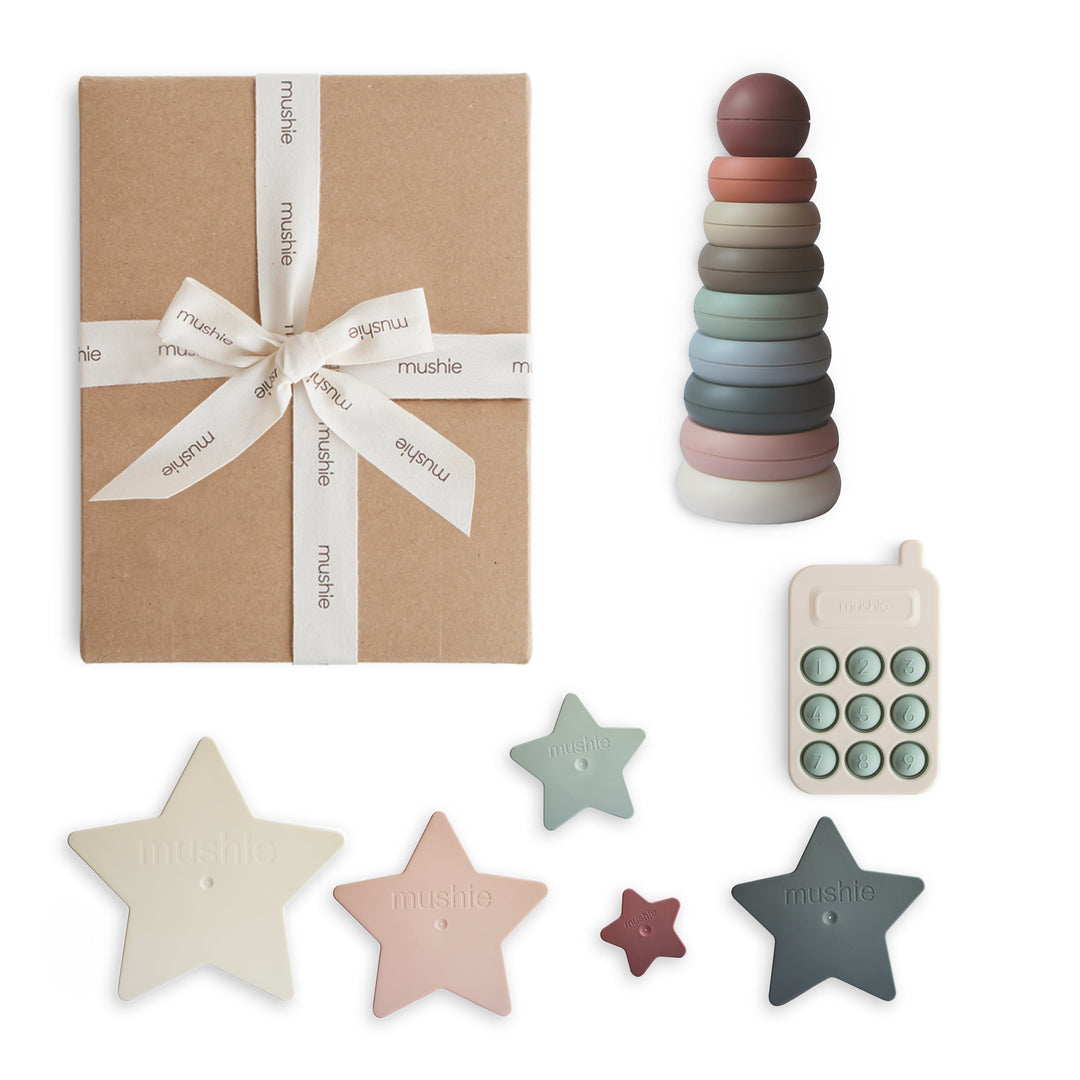 Mushie everyday play gift set with a phone press toy, nesting stars, and stacking rings in a kraft gift box