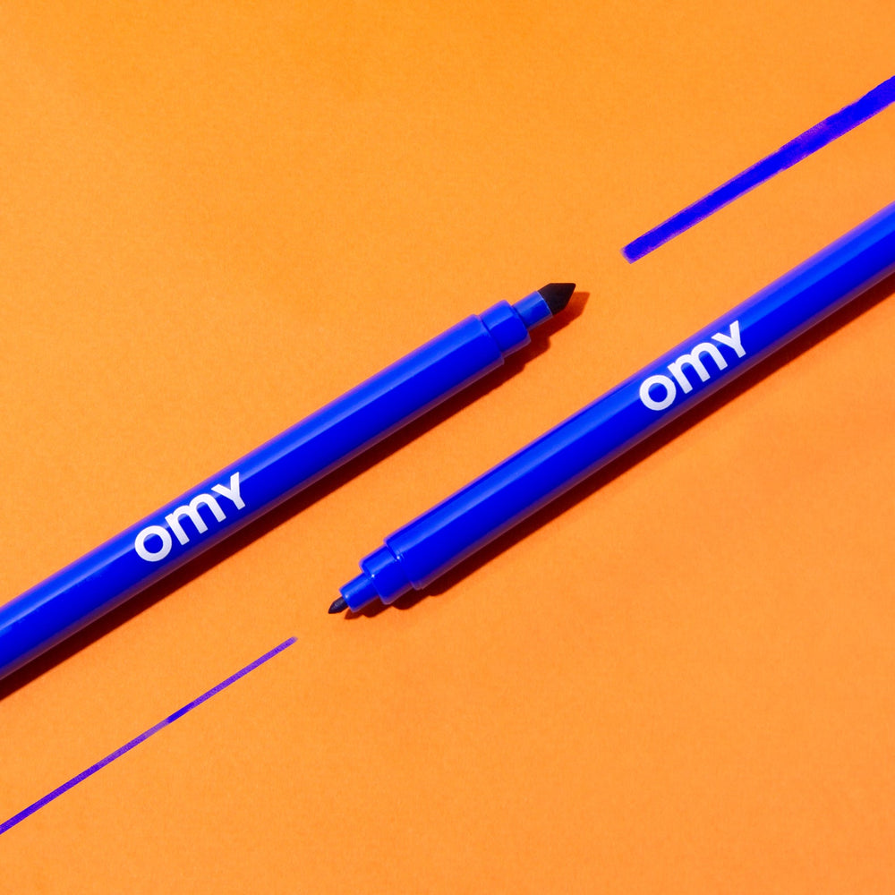 Two double-ended magic markers, one drawing a blue line, on an orange background