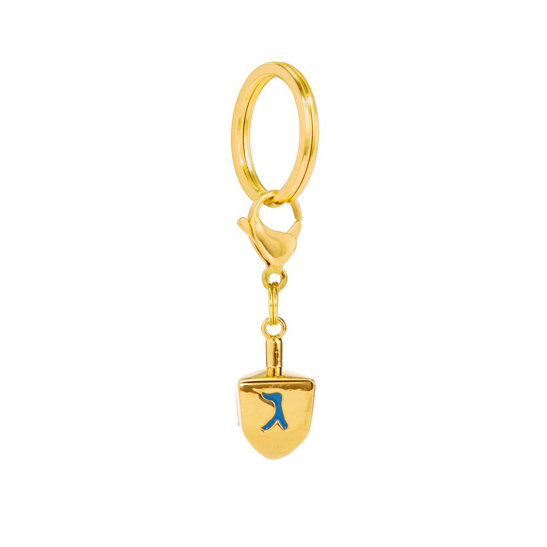 Gold dreidel dog charm turning on a split ring and clasp to show the Hebrew letters on each face