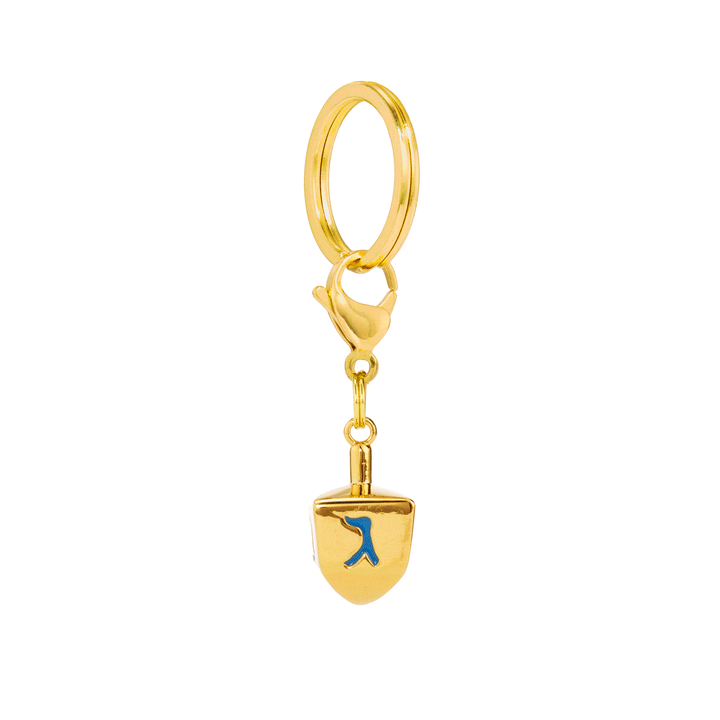 Gold dreidel dog charm turning on a split ring and clasp to show the Hebrew letters on each face