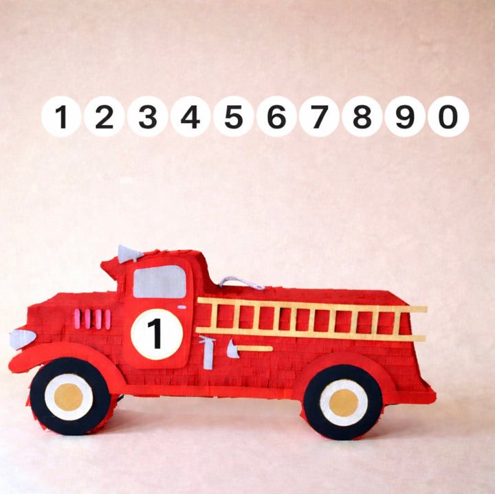 Red fire truck-shaped Pinata with a ladder on a beige background