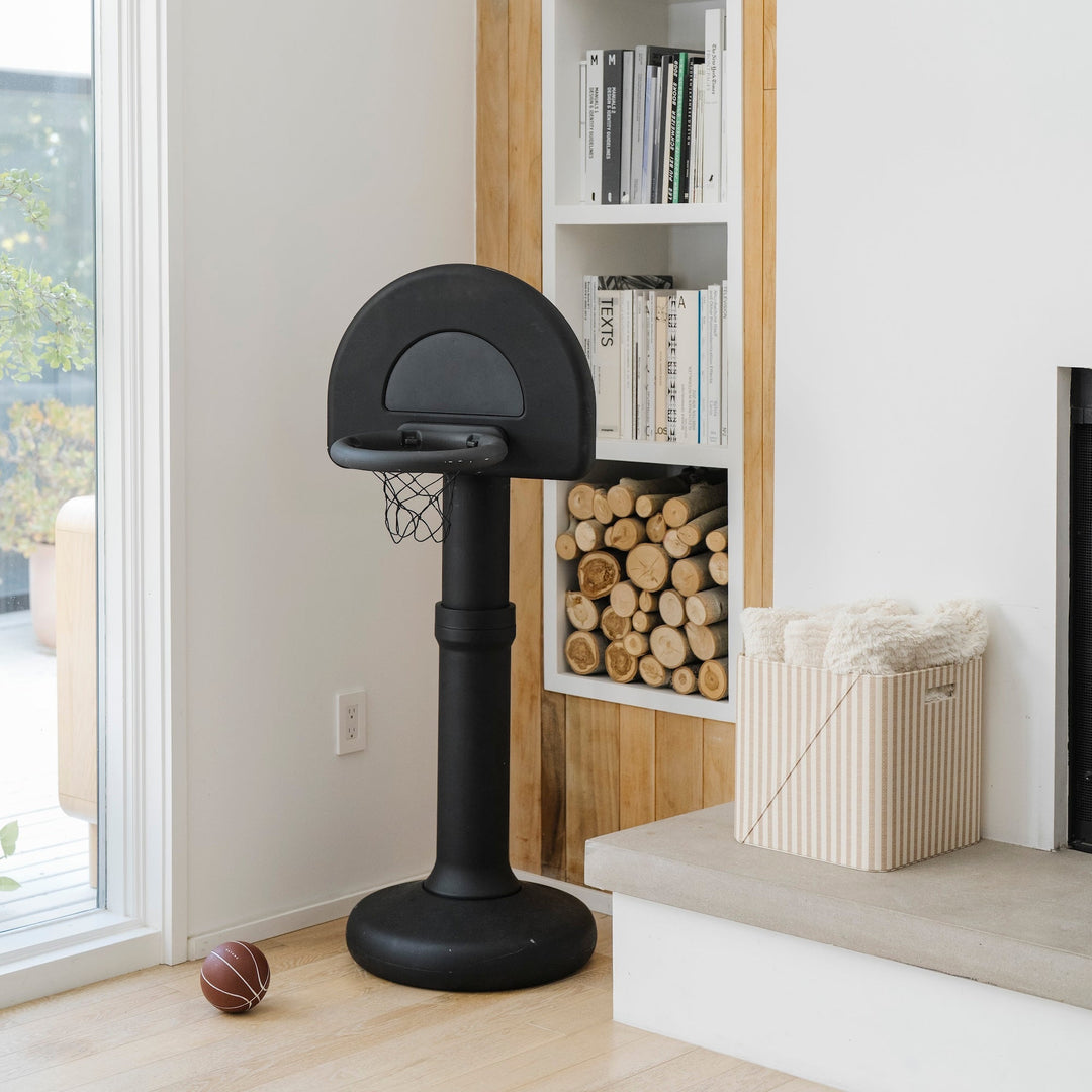 Raven black hoop in a modern living room beside a bookshelf and stacked firewood