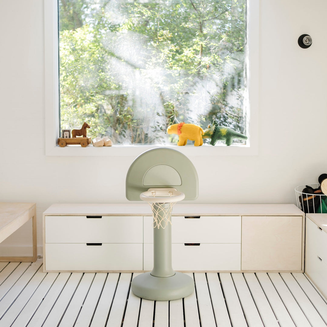 Palm green basketball hoop in a white playroom with a striped floor