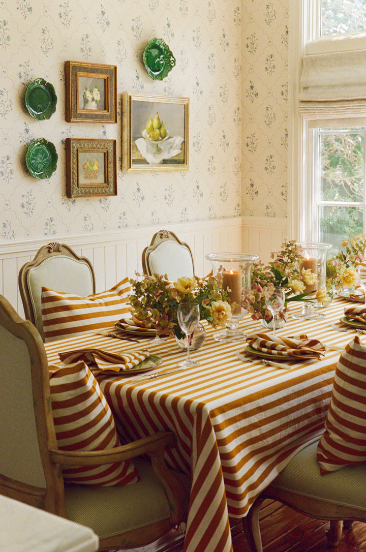 Goldenrod and cream stripe linens on a dining table set for a harvest dinner