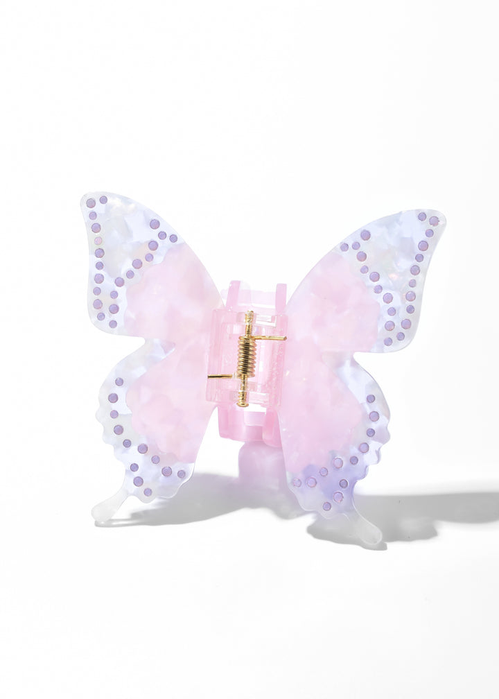Pink iridescent acrylic butterfly claw clip with dotted wing edges on a white background