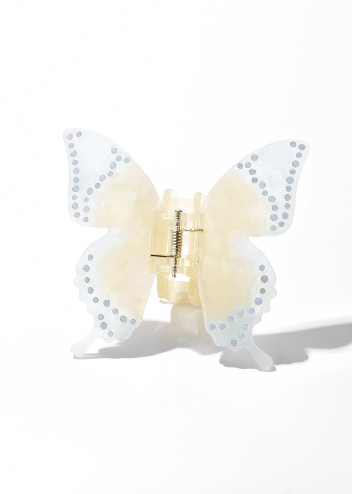 Yellow iridescent acrylic butterfly claw clip with dotted wing edges on a white background