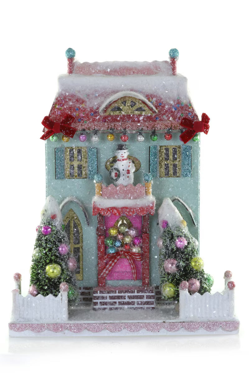 Mint glitter paper Christmas village house with a snowman, bottle brush trees, and ornaments for holiday decor