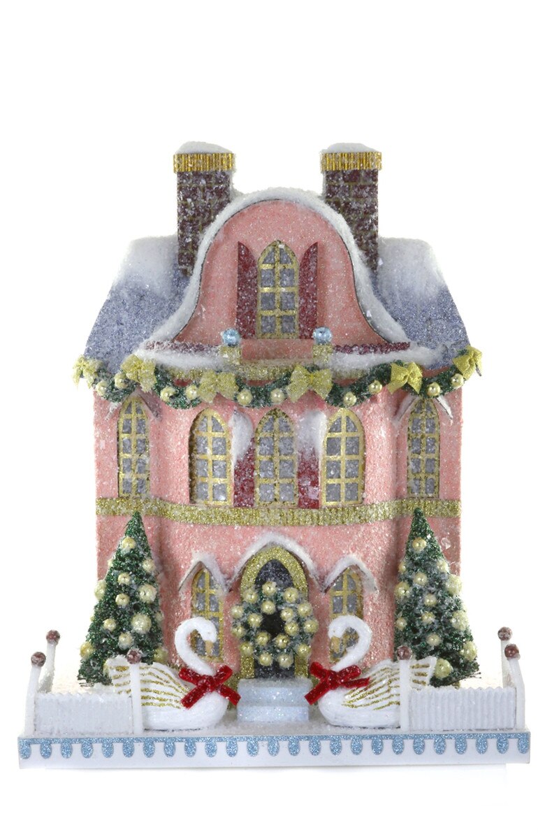 Pink glitter paper Christmas mansion with swans, garlands, and bottle brush trees for a holiday village display