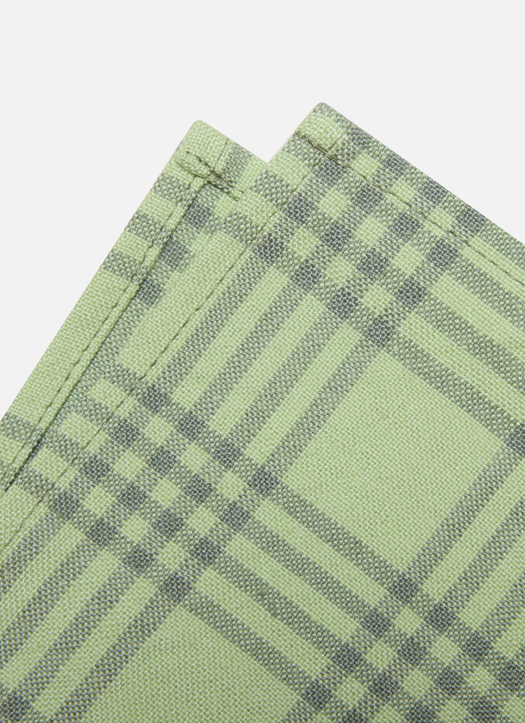 Two folded sage green cotton napkins showing the fine green check weave