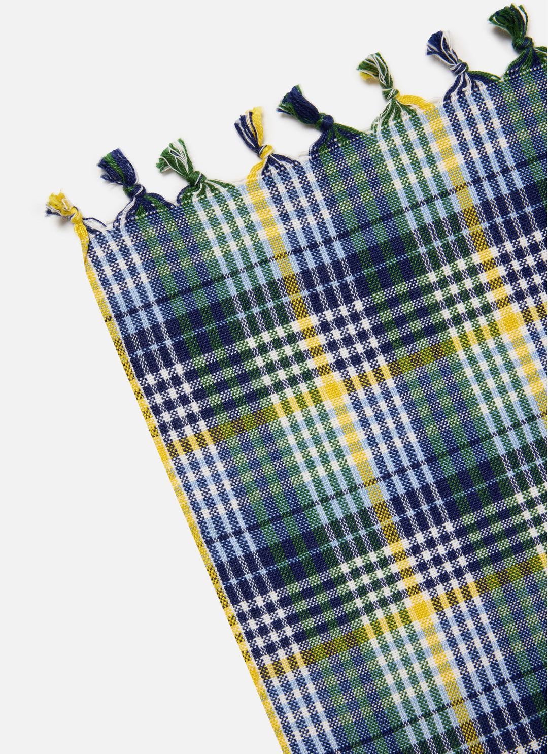 Corner of the Maine plaid tablecloth showing the knotted navy and yellow tassel trim