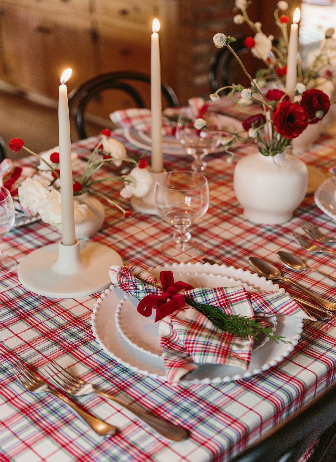 Close-up of the Clara plaid tablecloth corner showing knotted tassels and the cream weave