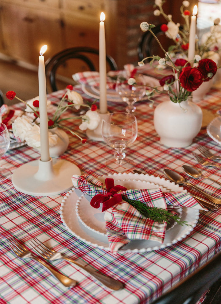 Close-up of the Clara plaid tablecloth corner showing knotted tassels and the cream weave